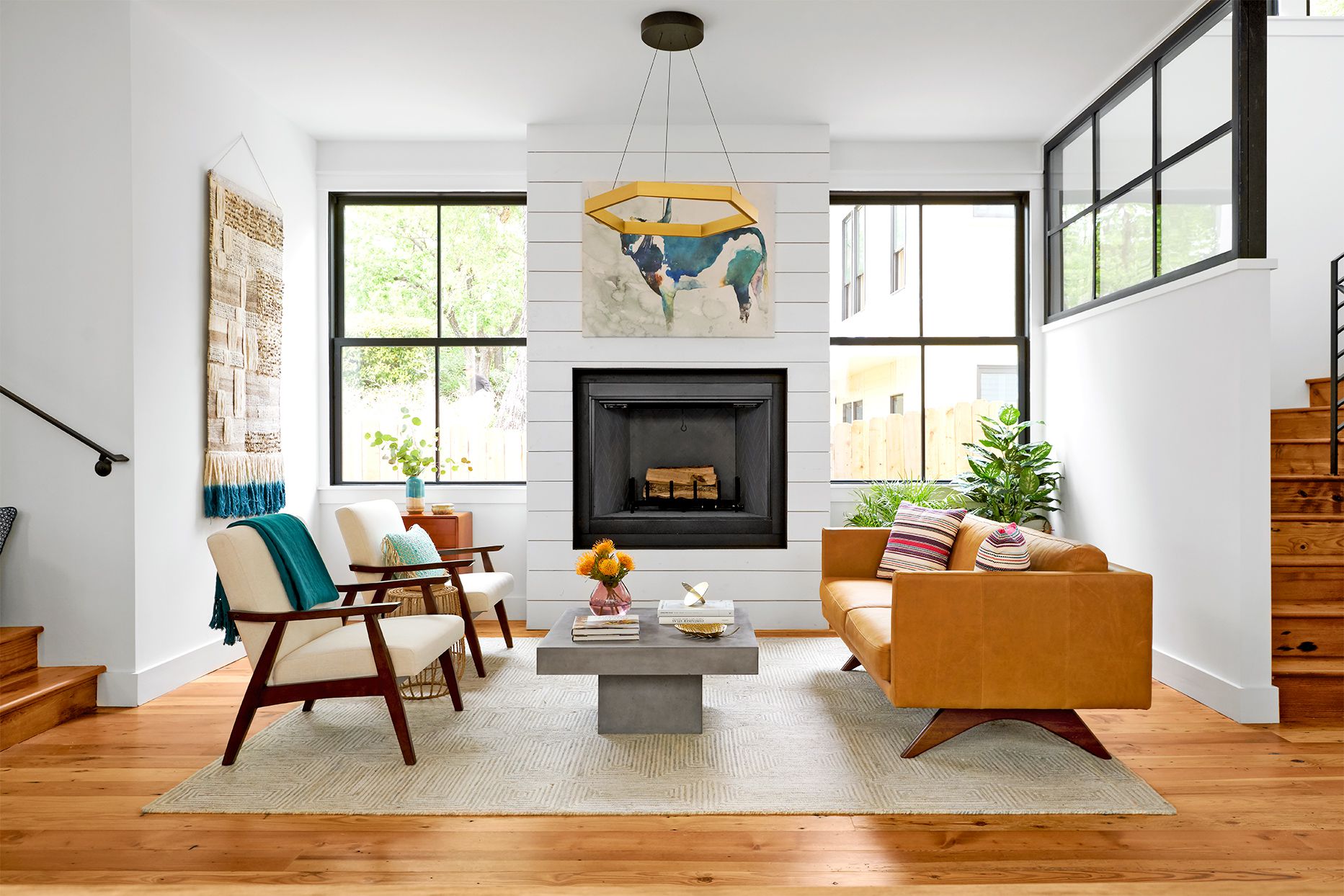 decoracion de una sala con pisos de madera, con chimenea, tapete en color claro y sobre el mesa de centro, sillon y sillas como parte de la decoracion | Pisos-de-Madera.mx