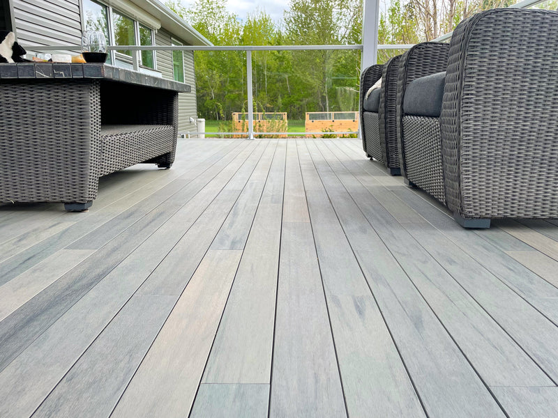 Ambiente de piso deck, con sillones en el exterior de casa con sillones para exteriores en tonos grises | Pisos-de-Madera.mx